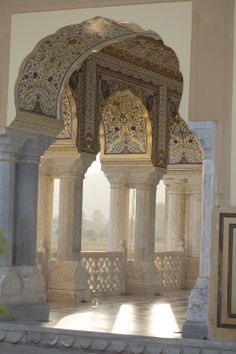 the inside of an ornate building with white and gold designs on it's walls