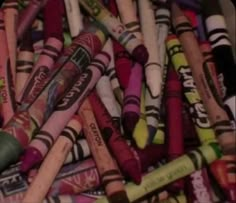 many different colored crayons are stacked together