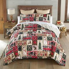 a bed covered in a red, white and black plaid comforter with christmas decorations on it