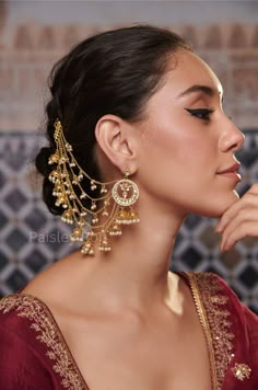 Experience the luxuriance of Gold-plated Kundan earrings, designed with an opulent Kundan-studded crescent motif outlined with shell pearls.  These  Sahara earrings are a straight-out-of-a-dream design, with long chains of small dangling jhumkis and pearls graciously moving with your steps. Entwined with time-honored customs and artful ingenuity, these Sahara Pearl earrings are the epitome of magnificence and poise. Closure - Push Back Weight- 76 gm (pair) Paisley Pop travels the depths of India to learn techniques and crafts from deep down in the local markets and villages. We give utmost importance to our quality and packaging. Our goal is to ensure you receive exactly what you are looking for and for your experience to be special and memorable. We are ready to help and advise you throug Earring To Hair Chain, Pearl Tassel Earrings Gold Indian, Luxury Latkans Dangle Earrings, Luxury Latkans Earrings, Hairstyles With Earrings, Luxury Kundan Jhumkas In Temple Jewelry Style, Cheap Chandbali Earrings With Latkans, Luxury Wedding Chandbali Pearl Earrings, Luxury Formal Necklace With Latkans