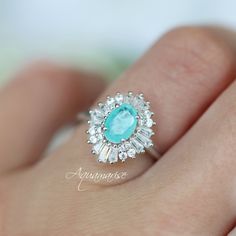 Victoria Neon Paraiba Tourmaline Ring ►Made of Sterling Silver, Rhodium Plated (S925) ►Accented with Simulated Diamonds (CZ) Center Stone: Paraiba Tourmaline Gemstone Creation: Lab-Created Stone Cut: Oval Color: Turquoise Gem size: 7.0 x 5.0 mm Carat Weight: 0.76 ct. Gemstone Origin: Brazil ►Handling time: 1-2 business days ►Free domestic USA shipping. Typically takes 2-5 business days. ►Wrapped & ready to give in a beautiful box. Turquoise Aquamarine Gemstone Rings, Turquoise Aquamarine Birthstone Ring, Fine Jewelry Aquamarine Ring In Turquoise, Elegant Silver Turquoise Ring With Birthstone, Elegant Silver Turquoise Birthstone Ring, Turquoise Cubic Zirconia Jewelry For Anniversary, Turquoise Emerald-cut Gemstone Ring, Turquoise Emerald Cut Gemstone Ring, Turquoise Gemstone Rings With Emerald Cut