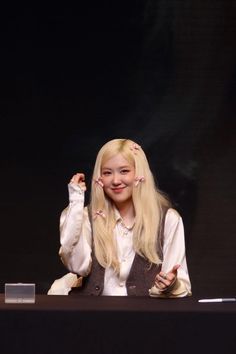 a woman with long blonde hair sitting at a table