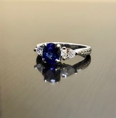 "DeKara Designs Collection Beautiful Modern/Art Deco Ceylon Blue Sapphire and Diamond Ring Metal- 90% Platinum, 10% Iridium Stones- Natural Oval Ceylon Blue Sapphire 1.34 Carats, 2 Trillion Cut Diamonds, F-G Color VS1 Clarity, 0.52 Carats. Size-6 1/4 Plus. FREE SIZING Classic and Timeless Art Deco Inspired Ceylon Blue Sapphire Oval Diamond Engagement Ring. The center sapphire is a beautiful deep blue in color, and is \"Eagle Claw\" prong set to perfection, with two Trillion Cut Diamonds that are Classic Trillion Cut Sapphire Ring, Sapphire-colored Diamond Ring With Accent Stones For Anniversary, Blue Diamond Ring With Accent Stones For Anniversary, Classic Trillion Cut Brilliant Sapphire Ring, Classic Sapphire Ring With Trillion Brilliant Cut, Classic Jewelry With Trillion Cut Center Stone, Fine Jewelry Sapphire Ring With Trillion Cut, Classic Three Stone Jewelry With Lab-created Sapphire, Classic Trillion Cut Sapphire Jewelry