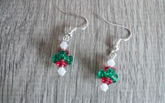 Beautiful Christmas dangle earrings designed with acrylic beads in the colors of red, green, and white. The ear wires are silver plated and nickel free. The earring drop measures 1 inch in length. #25 L(12) This beauty was designed and handmade by me. This item will be shipped in a white jewelry box and colorful organza bag. 10% of my sales from my Etsy shop will be donates to a no kill animal shelter in my area. www.animalhouseshelter.com Christmas Green Dangling Beads Earrings, Christmas Green Earrings With Dangling Beads, Reused Jewelry, Red White And Green Christmas, White And Green Christmas, Green Dangle Earrings, Beaded Memory Wire Bracelets, Diy Jewelry Unique, Rice Bags