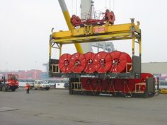 a large crane is holding many red reels