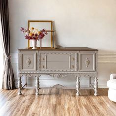 a white couch sitting next to a table with flowers on top of it in a living room