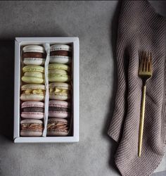 an open box with macaroons and a fork