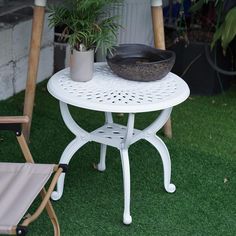 a potted plant sitting on top of a white table next to a wooden chair