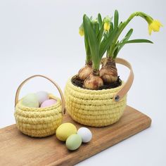 an easter basket with flowers and eggs on a cutting board next to it is decorated with yellow tulips