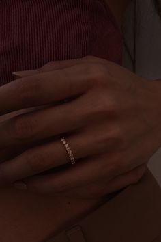 a woman's hand with a diamond ring on her left wrist, wearing a red top