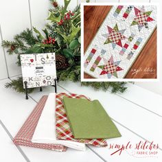 christmas quilts and napkins sitting on a table next to a potted plant