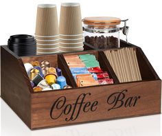 a wooden coffee bar with cups and other items in the trays on top of it