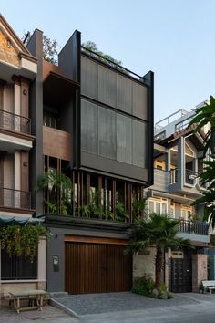 an apartment building with multiple balconies and plants on the top floor, next to a parking lot