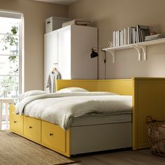 a bedroom with a bed, book shelf and window