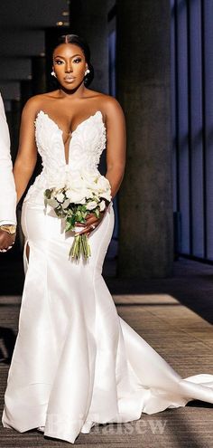 the bride and groom are walking down the aisle together in their wedding gowns, holding hands