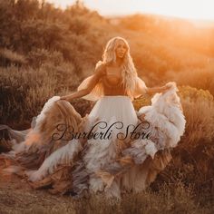 a woman in a white dress standing on a hill