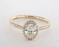 an oval cut diamond ring with pave set diamonds on the band and halo setting