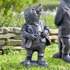 a statue of a little boy standing in the grass with his eyes closed and hands folded