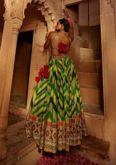 Make a style statement like a traditional diva in this alluring lehenga set featuring a geometrical print skirt with a multi-colour embroidered border and an intricately embroidered blouse styled with a coordinated dupatta. Green Georgette Lehenga With Cutdana, Green Georgette Lehenga With Cutdana Details, Green Floor-length Palazzo Set For Navratri, Green Bohemian Palazzo Set For Navratri, Green Palazzo Set With Unstitched Blouse For Reception, Green Bohemian Set With Traditional Drape, Bohemian Green Set With Traditional Drape, Green Bohemian Designer Dress, Green Palazzo Set With Unstitched Blouse For Festivals