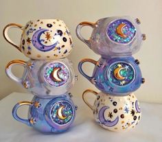 three glass coffee mugs stacked on top of each other with the moon and stars painted on them