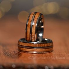 two wedding rings with wood inlays on a table