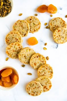 several small crackers are on the table next to some pumpkins and seeds,