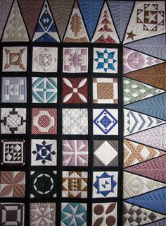 a quilted wall hanging with many different designs on it's sides, including squares and triangles