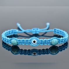 Durable Hand-Made Light Blue String Bracelet With An Evil Eye And Semi-Precious Howlite Stones For Wrist Sizes 6 To 9 In. With An Easy To Use Zip Like Function To Fit Your Wrist, You'll Have It On As Soon As You Get It! Made From High-Quality Light Blue String, It Will Be Sure To Last. Wearing An Evil Eye As An Amulet Is Believed To Provide Protection Against Evil Forces. The Evil Eye Meaning Has Symbolism In Almost Every Country In The World And In Every Religion. Each Bracelet Is Carefully Han Blue Adjustable Braided Bracelets For Beach, Adjustable Blue Braided Bracelets For Beach, Blue Adjustable Braided Bracelet For Beach, Casual Blue Beaded Bracelets, Adjustable Turquoise Bracelets With Evil Eye, Blue Adjustable Braided Bracelets As Gift, Casual Blue Friendship Bracelets With Evil Eye, Blue Braided Bracelet With Adjustable Length As Gift, Blue Adjustable Braided Bracelet For Gift