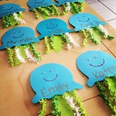 there are many blue and green items on the table with name tags attached to them