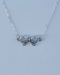 Small, sweet sterling bow hangs from a fine sterling chain with an alligator clasp closure. Cute Silver Charm Necklaces With Lobster Clasp, Cute Silver Charm Necklaces For Party, Cute Silver Jewelry With Adjustable Chain, Dainty Silver Charm Necklaces For Parties, Sterling Silver Charm Necklace With Delicate Chain For Party, Cute Sterling Silver Charm Necklace, Cute Jewelry With Butterfly Knot For Gifts, Dainty Sterling Silver Charm Necklaces For Parties, Cute Butterfly Knot Jewelry For Gifts