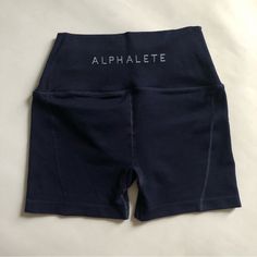 Alphalete High Rise Revival Shorts, Size Small. Navy Blue. New Condition, Never Worn. Squat Proof. Activewear / Gym Wear, Also Cute Worn Casually. Tag Size - Small Brand - Alphalete Condition - Brand New Waist 12” Inseam 4” #Alphalete #Shorts #Small #Revival #Highrise Blue Bottoms With Letter Print, Short Length, Blue Letter Print Shorts, Blue Stretch Activewear With Letter Print, Blue Workout Activewear With Letter Print, Blue Letter Print Activewear For Summer, Navy Stretch Training Shorts, Navy Stretchable Training Shorts, Navy Stretch Shorts For Training, Fitted Sports Shorts With Letter Print