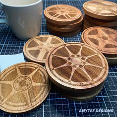 four wooden coasters with wheels on them next to a coffee cup and saucer