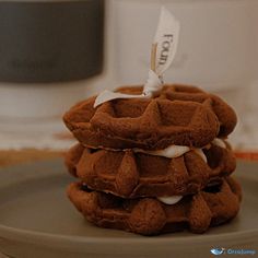 three chocolate waffles stacked on top of each other with white icing in the middle