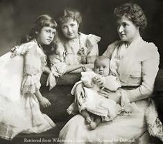 an old black and white photo of three women holding a baby