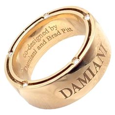 About This Piece: The Damiani Brad Pitt ring is a masterful blend of luxury and design. Crafted in exquisite 18k yellow gold, this size 5.5 band radiates opulence with 10 sparkling diamonds embedded within. The wide band profile elevates its prominence on the wearer's finger. Co-designed by Brad Pitt, it carries not just the weight of precious metals and gemstones but also the prestige of a celebrity touch, making it a statement piece for any collection. Retail Price: $3,590  Damiani Box + Paper Luxury 14k Gold Diamond Ring, Luxury Gold Diamond Ring With Single Cut Diamonds, Luxury Gold Diamond Ring With Diamond Accents, Luxury Gold Diamond Ring With Accents, Luxury Gold Rings With Single Cut Diamonds, Elegant Gold Engraved Ring With Diamond Accents, Elegant Yellow Gold Engraved Ring With Diamond Accents, Elegant Engraved Yellow Gold Ring With Diamond Accents, Timeless Gold Engraved Ring With Diamond Accents