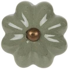 a green flower shaped object with a gold ball in the center