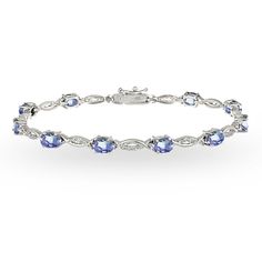 This gorgeous tennis bracelet displays glistening oval-cut 6x4mm tanzanite gemstones that are set in between a polished and white topaz studded swirl design. The bracelet is created of 925 sterling silver and is tarnish resistant plus nickel free. It secures with a box and tongue with a safety latch. Look and feel glamorous with this luxurious piece of jewelry! Product Details Metal Type sterling-silver Metal Stamp 925-sterling Weight 8.5GR Length 7.25IN Width 4.85MM Clasp Type box-with-tongue-a 13th Birthday Gift Ideas, Christmas Gifts For Daughter, Indian Diamond Jewellery, Basic Bracelet, Happy Christmas Day, Mens Diamond Bracelet, Anklet Designs, Gifts For Daughter, Moon Princess