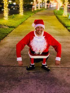 a man dressed as santa claus poses for a photo in front of some christmas lights