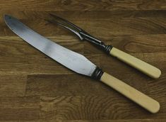 two knives sitting on top of a wooden table