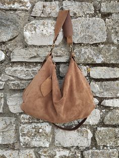 Features : - tan suede, - Tan suede strap, - Zipped bag, - Unlined, - Inside cotton zipped pocket, - Leaf-shaped leather label. Size: - Height 12 inch, - Lenght (opening of the zip)14 inch, - Length max 17 inch, - Depth 3 inch, - Shoulder belt is adjustable 24/47 inch. Buy the leather tassel to embellish your bag: https://www.etsy.com/it/listing/1277946623/nappina-portachiavi-in-pelle-marrone? Handmade soft tan suede hobo bag. The bag is closed with a metallic zip.  Inside is unlined and there i Chic Suede Hobo Bag With Suede Lining, Soft Leather Suede Satchel Shoulder Bag, Chic Suede Hobo Bag With Soft Leather, Everyday Suede Shoulder Bag With Suede Lining, Suede Shoulder Bag With Suede Lining For Everyday Use, Suede Shoulder Bag For Everyday Use, Chic Soft Suede Hobo Bag, Camel Leather Hobo Bag With Adjustable Strap, Suede Lined Hobo Shoulder Bag