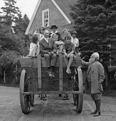 an old black and white photo of people riding in a horse drawn carriage