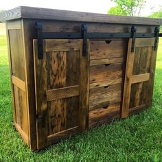 an outdoor storage area made out of wood and metal hardware on the grass with trees in the background