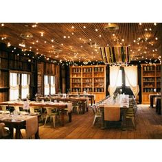 the dining room is set up for an event with long tables, chairs and bookshelves