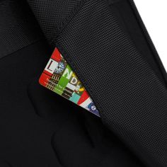 an id badge is attached to the back of a black backpack with multicolored stickers on it