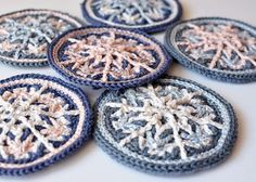 six crocheted snowflakes are arranged on a table