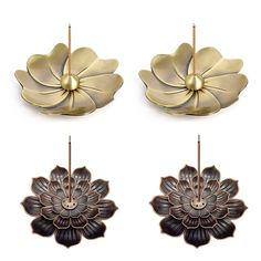 three flower shaped metal objects on a white background, one is gold and the other two are silver