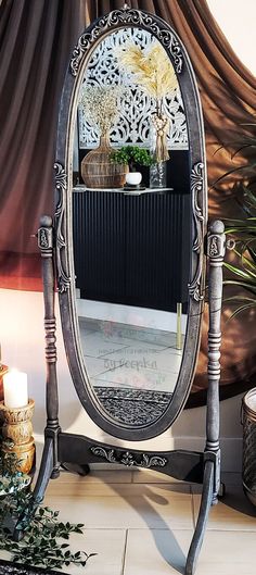 an ornately decorated mirror is on display in front of a table with candles and flowers