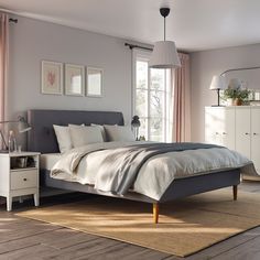 a bedroom with a bed, dressers and windows in it's center area