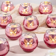 many pink glass candles with gold butterflies on them