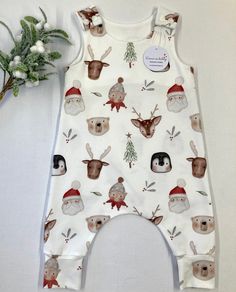 "Santa's friends print organic romper, fun baby and toddler wear, baby gift, baby clothes, stretchy dungarees, handmade to order. This beautiful organic romper is the ideal baby outfit, bringing festive joy and fun to baby wear.  Rompers are made using a harem style pattern  to provide extra room for your little one to grow and move freely. I use high quality GOTS certified, organic jersey which is perfect for delicate skin.  Each romper has two KAM shoulder poppers to provide quick and easy nap White Printed Playful Jumpsuits And Rompers, Playful White Bodysuit As A Gift, Playful White Bodysuit As Gift, Playful White Bodysuit Gift, Cute Cotton Onesie For Holidays, Playful Cotton Bodysuit As A Gift, Cute Cotton Christmas Onesie, Cute Christmas Cotton Onesie, Baby Dungarees